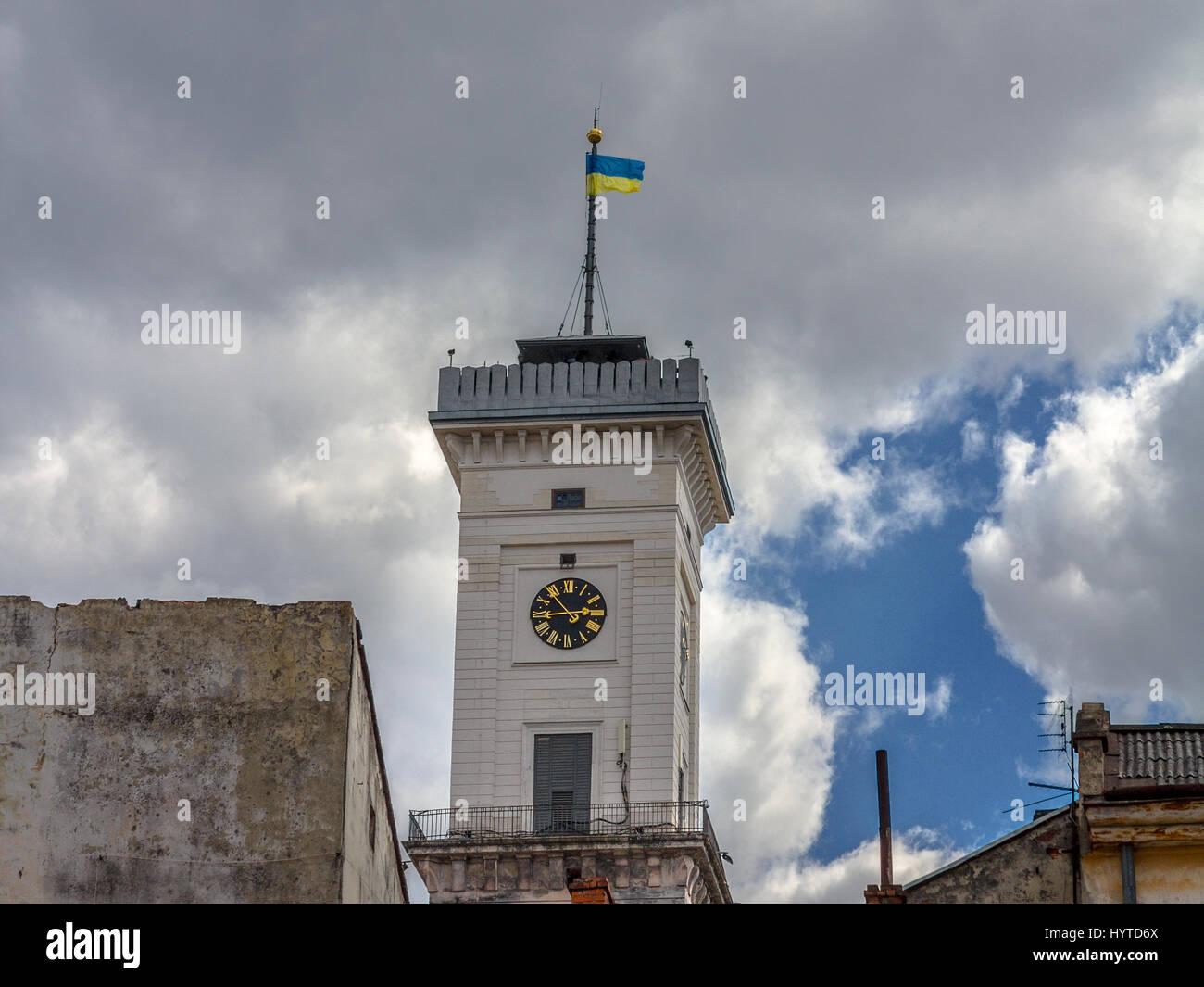 Ukrainische Flagge an der Spitze der Lemberg Rathaus Uhr Turm, Ukraine, mit einem bewölkten Hintergrund Bild von Lemberg Rathaus Glockenturm, eine Flagge der Ukraine ein Stockfoto