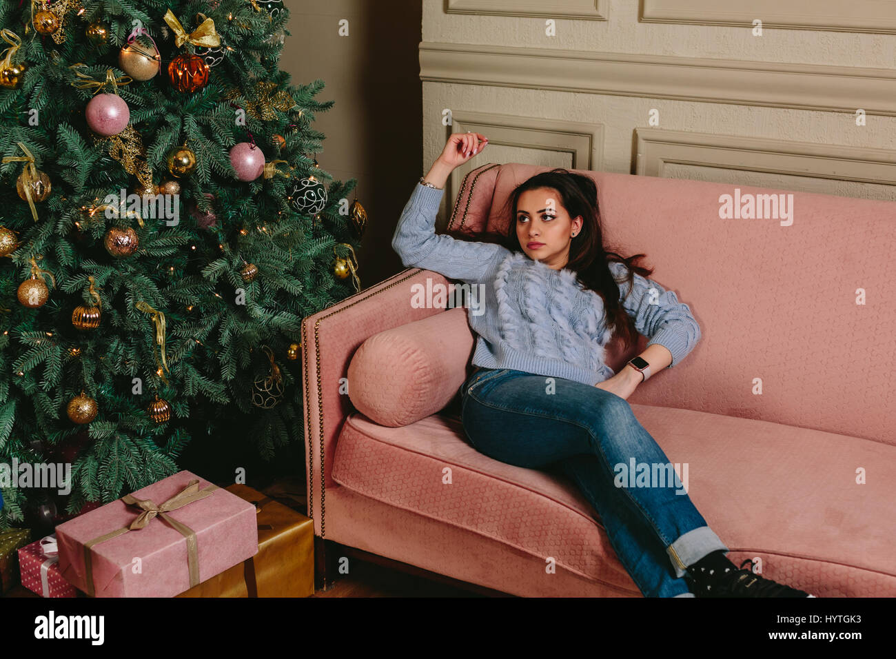 Schön müde Mädchen Weihnachtsbaum sitzen auf der Couch zu betrachten. Horizontale Studioportrait. Stockfoto