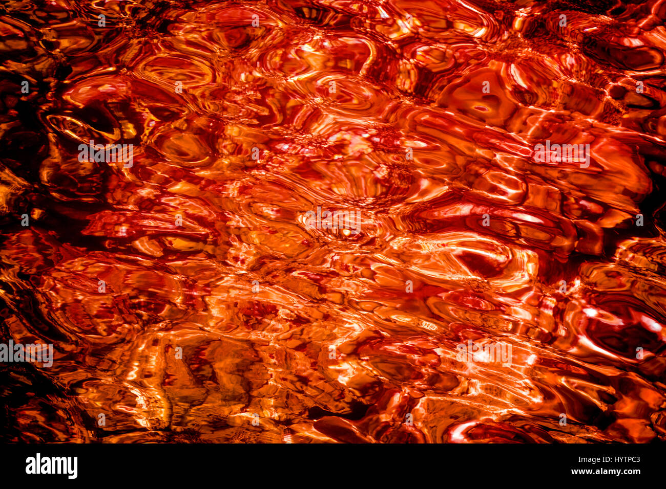 Blut rote Flüssigkeit Wasseroberfläche im Abendlicht. Abstrakt Hintergrund Stockfoto