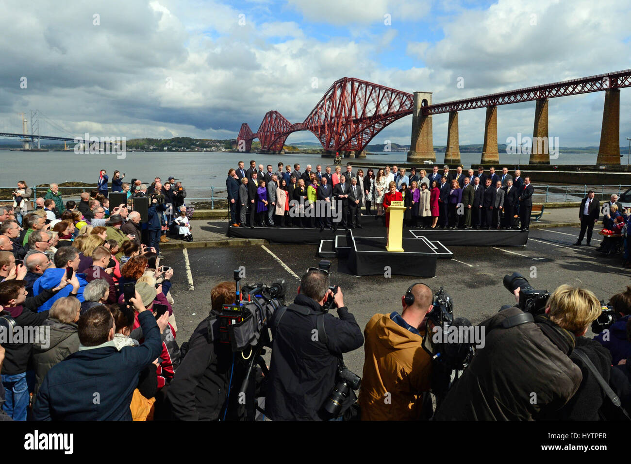 SNP-Führer und schottischen ersten Minister Nicola Sturgeon hält eine Rede, umgeben von der Gruppe von 56 neu gewählte SNP MPs mit die Forth Bridge im Hintergrund Stockfoto