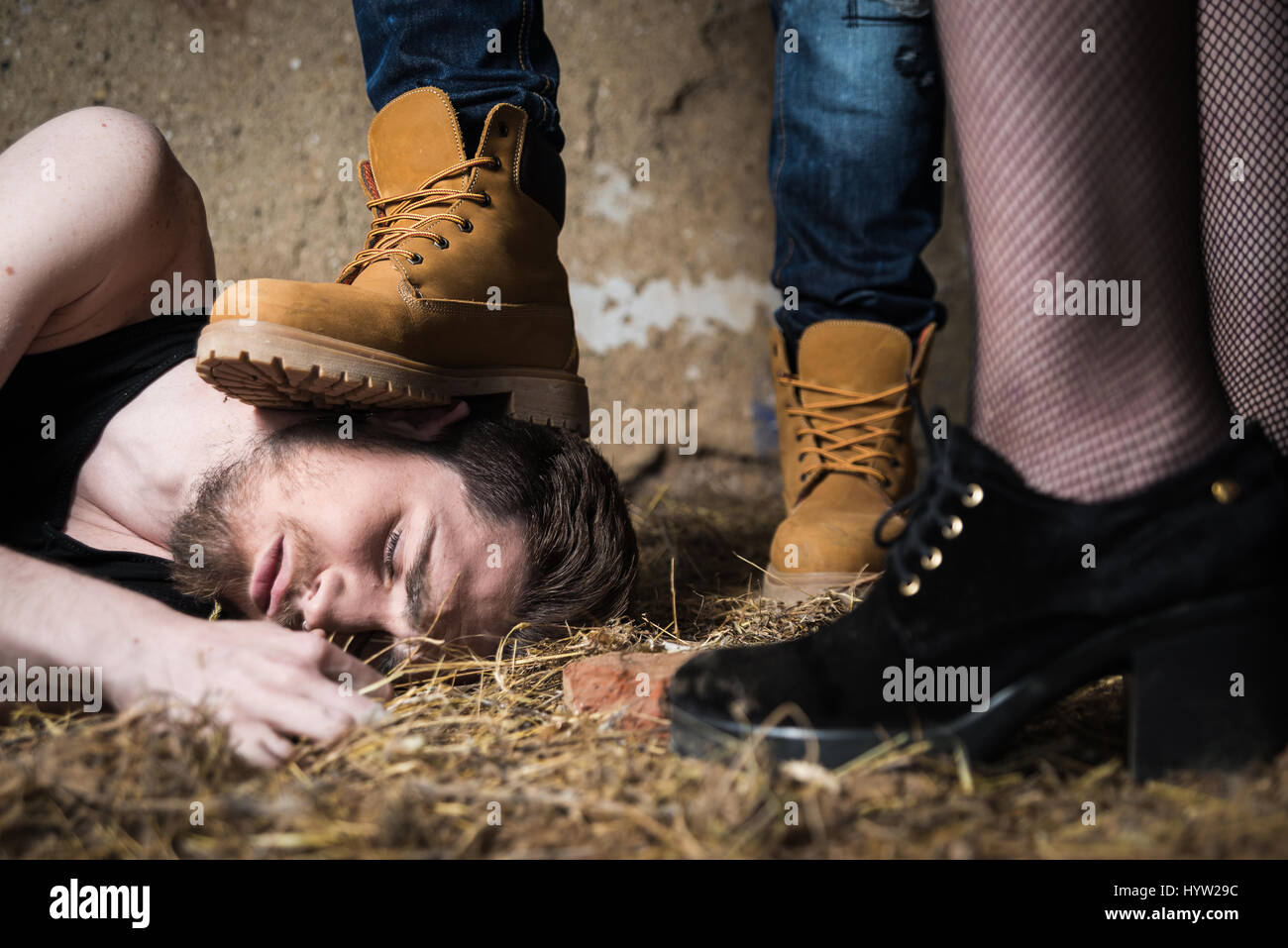 Nahaufnahme von einem mans Fuß zerquetschen Männerkopf. Homophobe Menschen Stockfoto