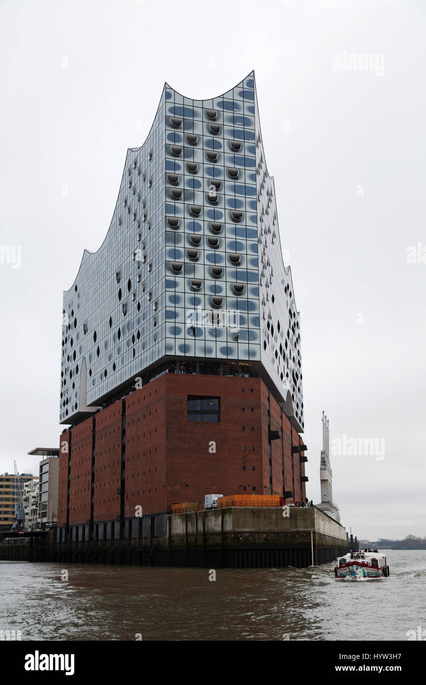 Ein Boot geht die Elbphilharmonie in Hamburg, Deutschland. Die Mehrzweck-Gebäude in der HafenCity-Bezirk der Stadt hält ein Hotel, Apartment bauen Stockfoto