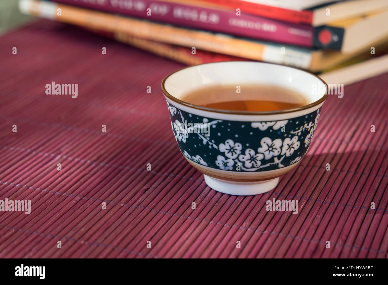 Nahaufnahme von einer Tasse Tee und Bücher in einem Outdoor-schattigen Licht Ambiente Stockfoto