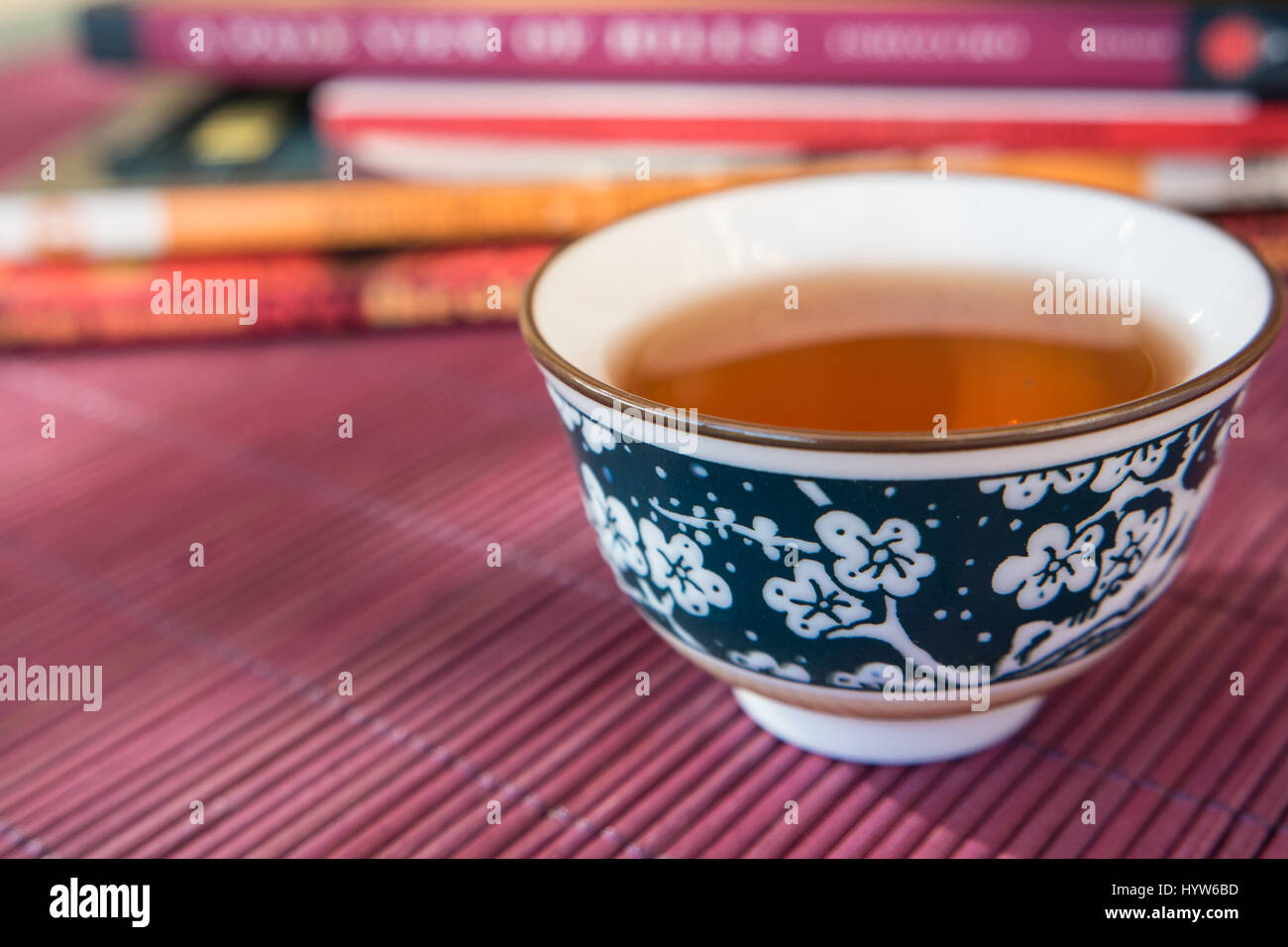 Nahaufnahme von einer Tasse Tee und Bücher in einem Outdoor-schattigen Licht Ambiente Stockfoto