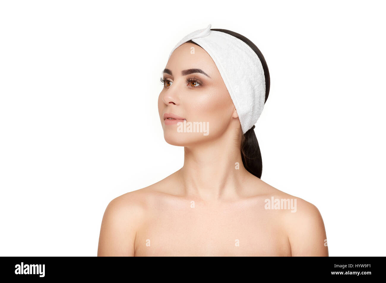 Porträt von schöne Brünette Frau, nach der Kosmetikerin, tragen in der Bandage am Kopf drehte sich um und wegsehen. Konzept der Schönheit, Pflege, Kosmetik, wel Stockfoto