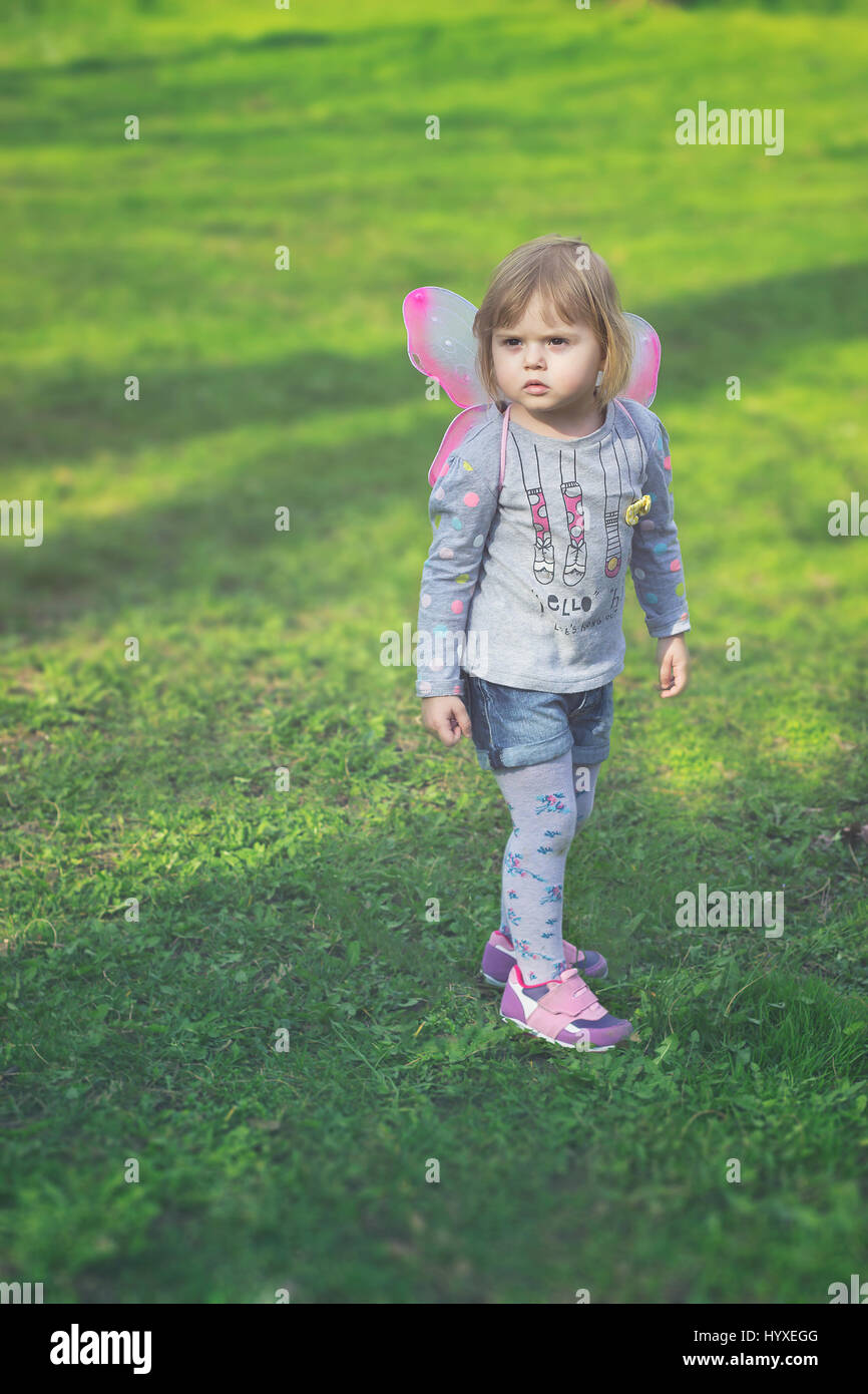 Hübsches Kleinkind Mädchen mit Schmetterlingsflügeln, spielen im park Stockfoto