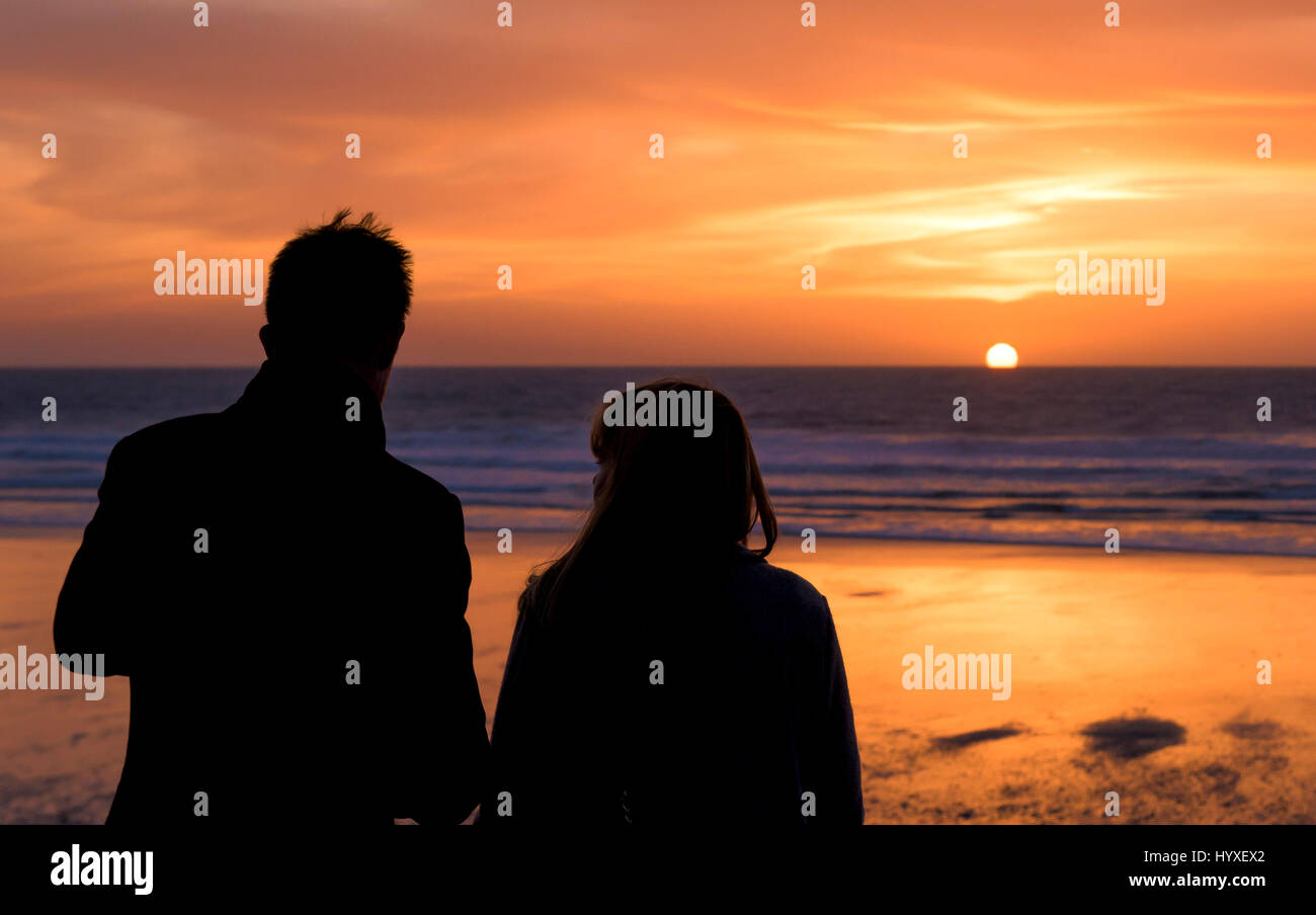 Sonnenuntergang Menschen Silhouette paar am Meer untergehenden Sonne Küste Fistral Strand Abend ausklingen des Tages Dämmerung Meer Ozean Freizeit Tourismus Stockfoto