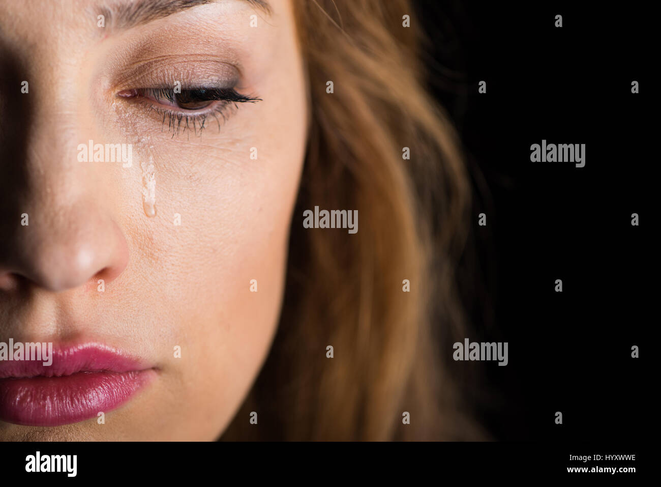 Nahaufnahme von jungen Weinen Gesicht der Frau auf schwarz Stockfoto