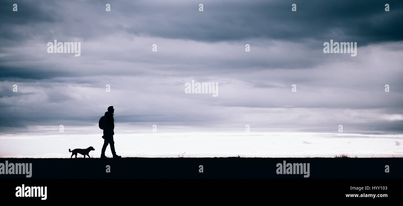 Silhouette der Wanderer und Hund zusammen spazieren Stockfoto