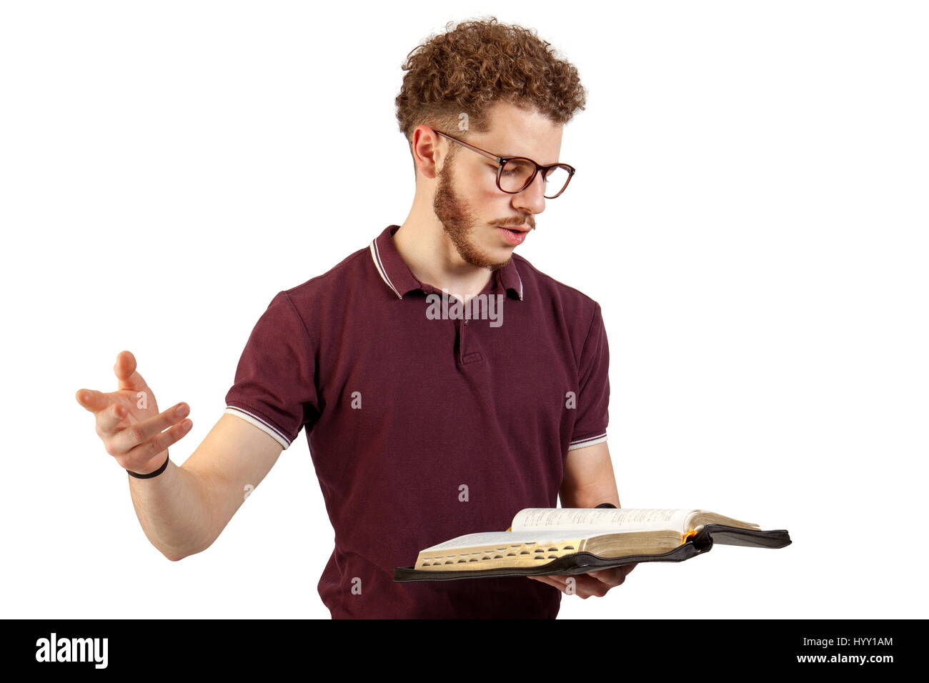 Junger Mann lesen aus der Bibel auf weißem Hintergrund Stockfoto