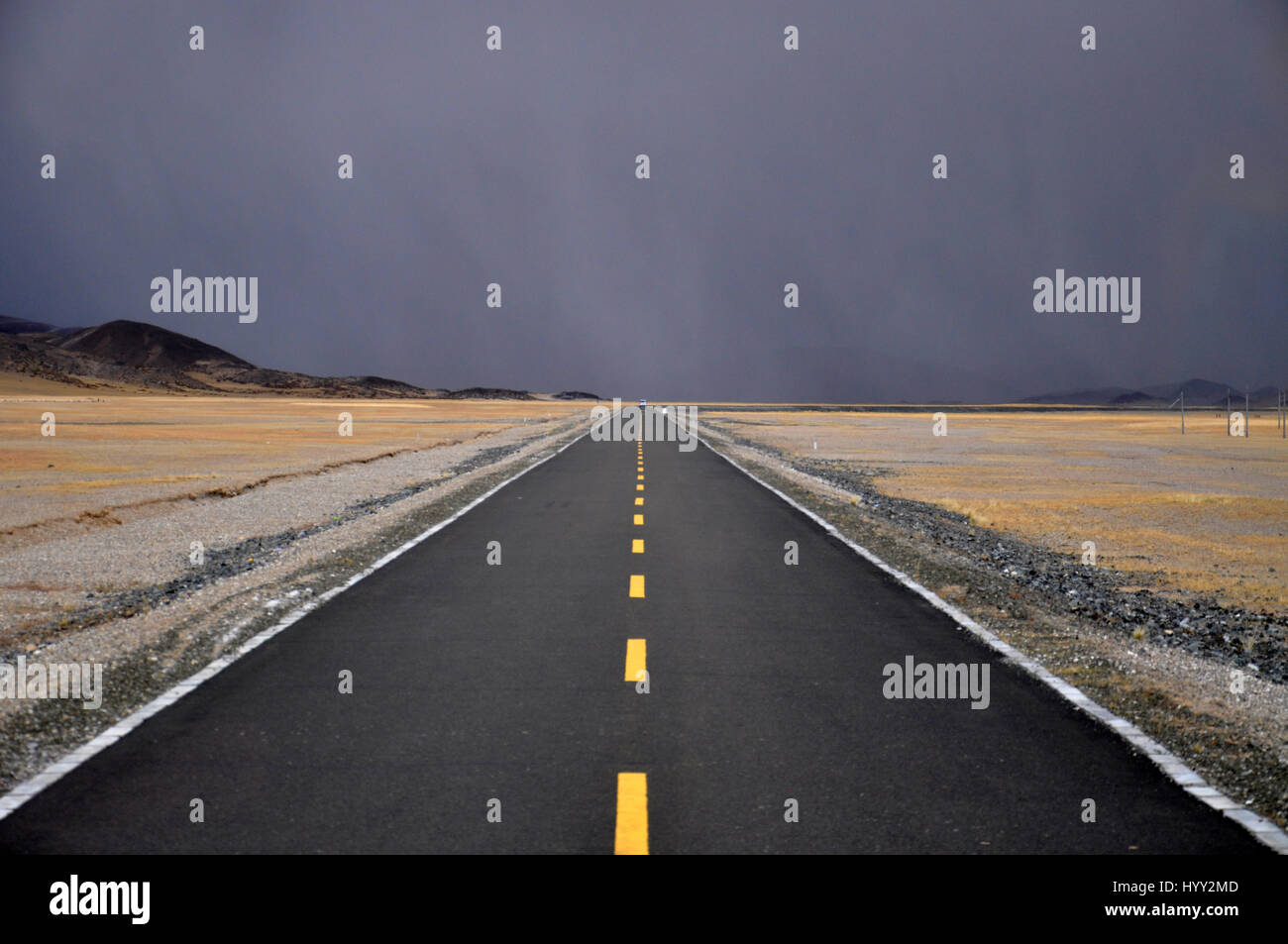 Asphalt-Road-Trip in stürmischen Wolken irgendwo in Tibet Stockfoto