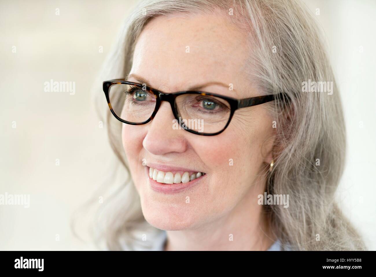 Ältere Frau mit Brille, lächelnd. Stockfoto