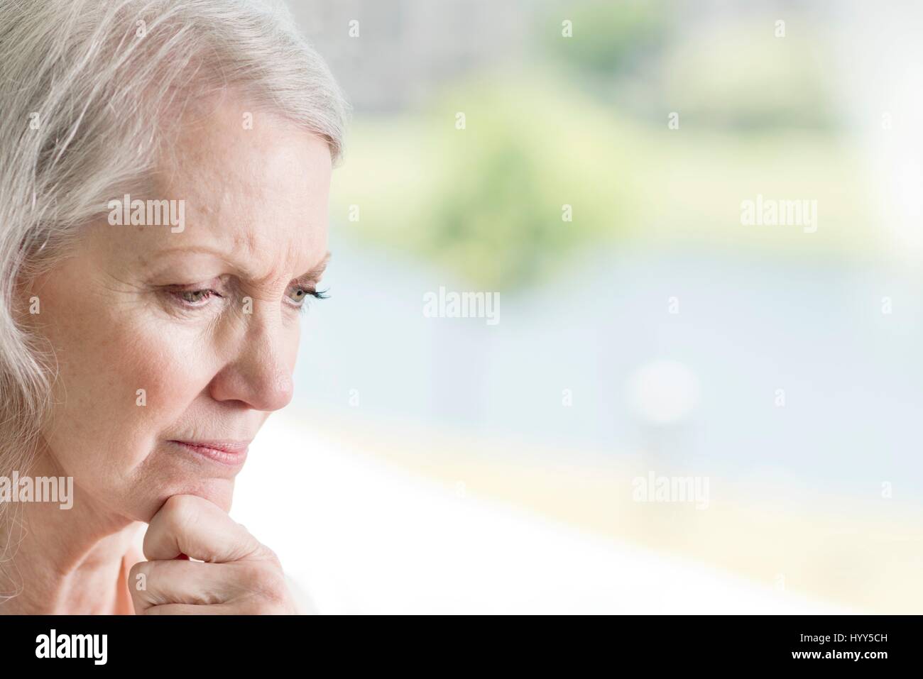 Ältere Frau mit Hand am Kinn. Stockfoto
