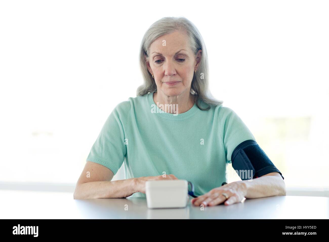 Ältere Frau die eigene Blutdruckmessung. Stockfoto