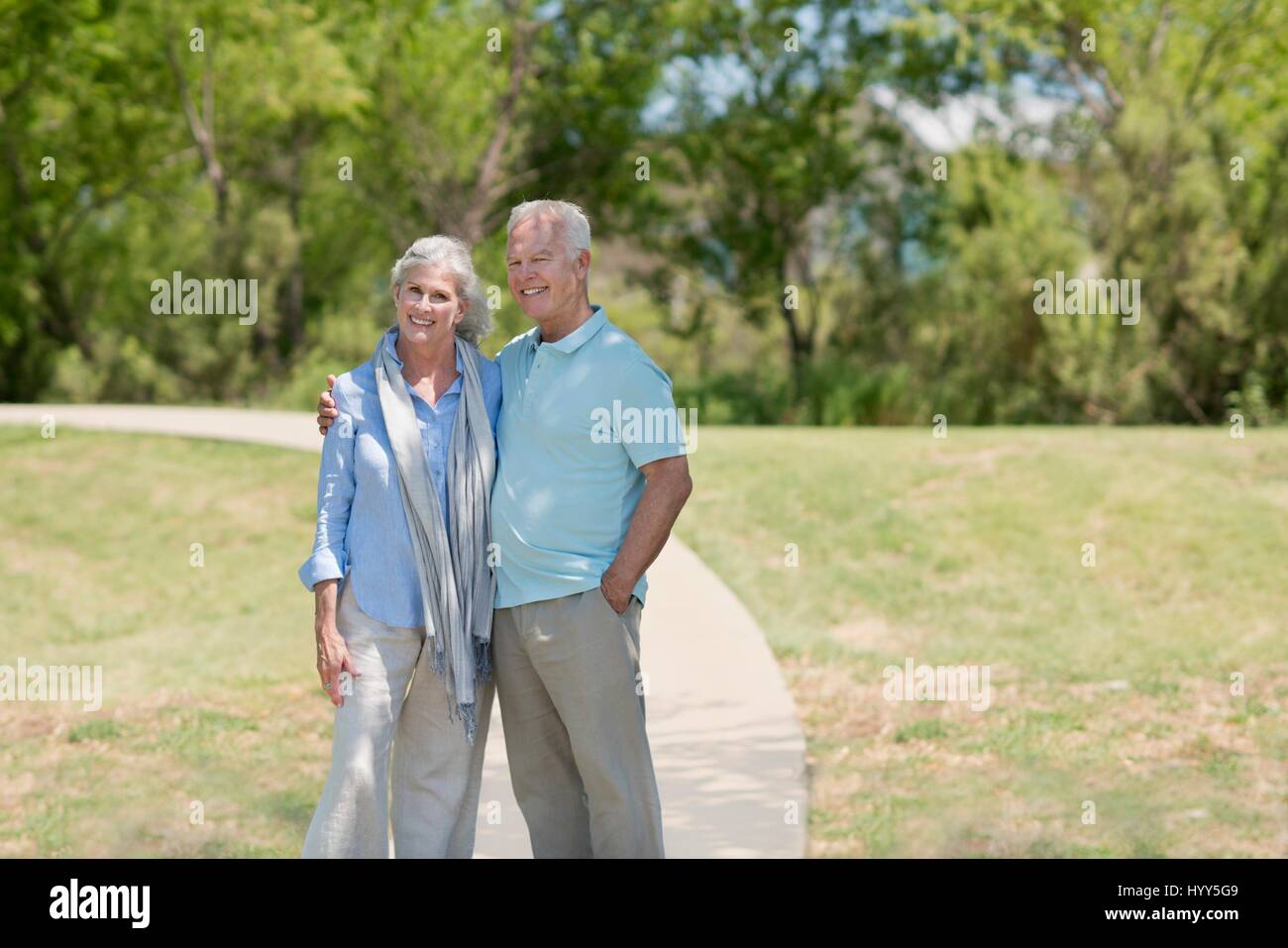 Älteres paar stehen im Park, lächelnd. Stockfoto
