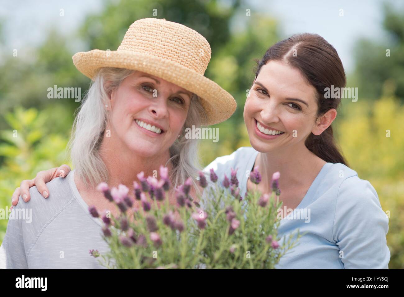 Ältere Frau und Tochter halten Topfpflanze. Stockfoto