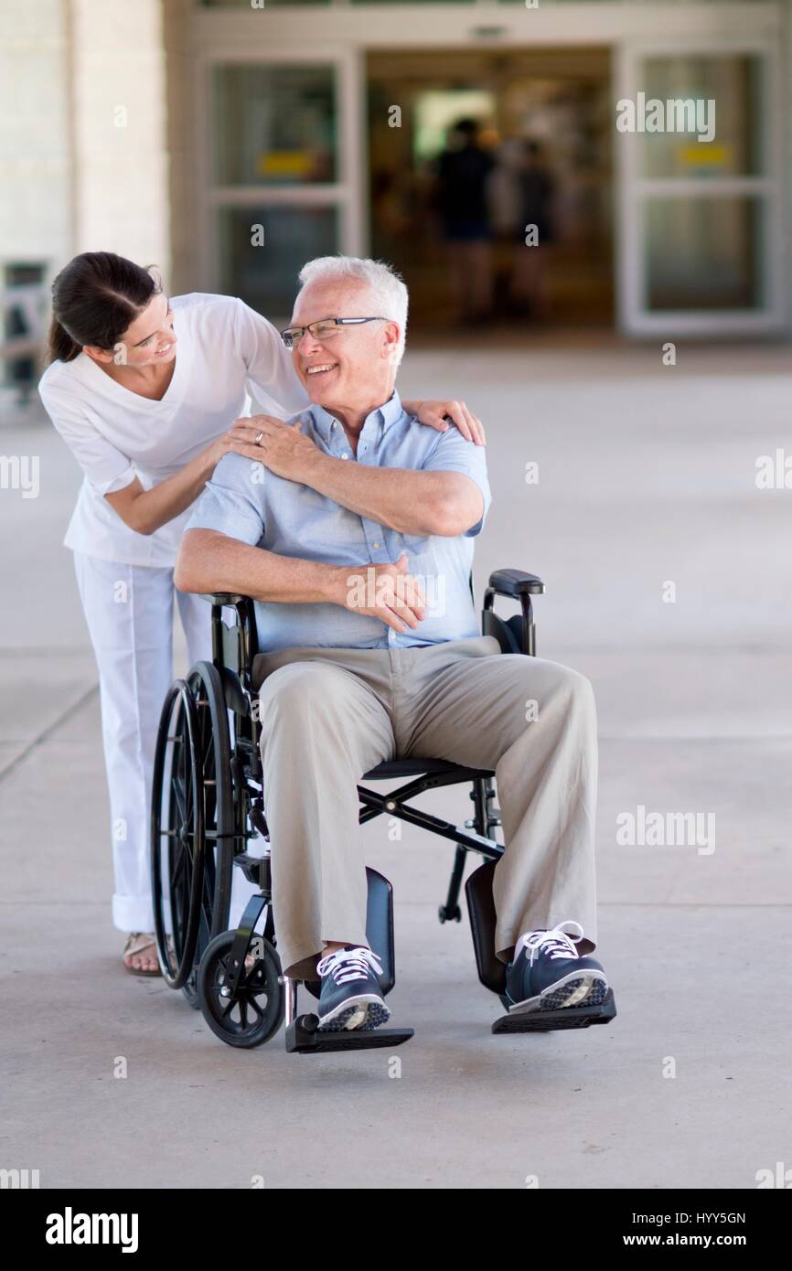 Ältere Mann im Rollstuhl mit Pflegedienst. Stockfoto