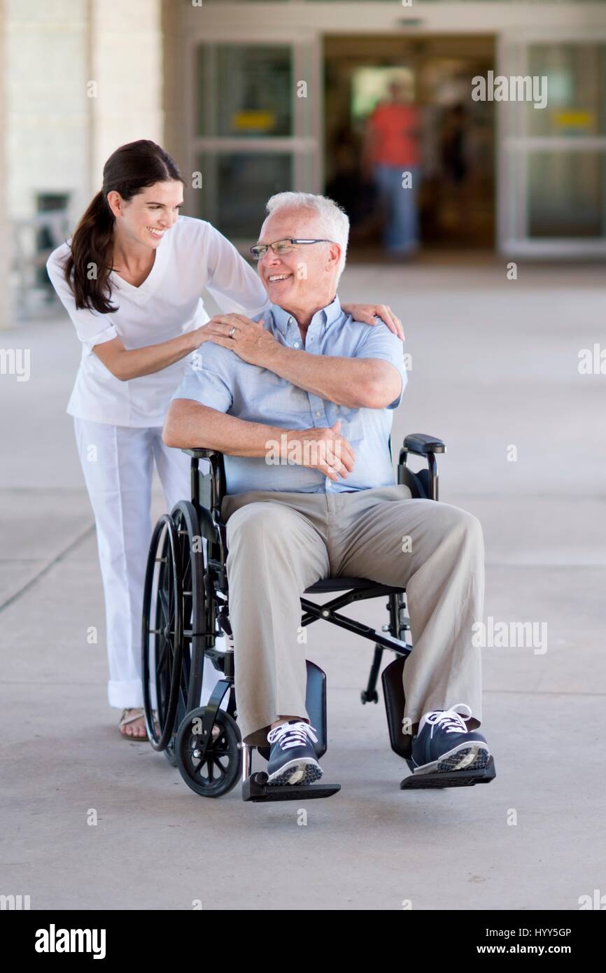 Ältere Mann im Rollstuhl mit Pflegedienst. Stockfoto