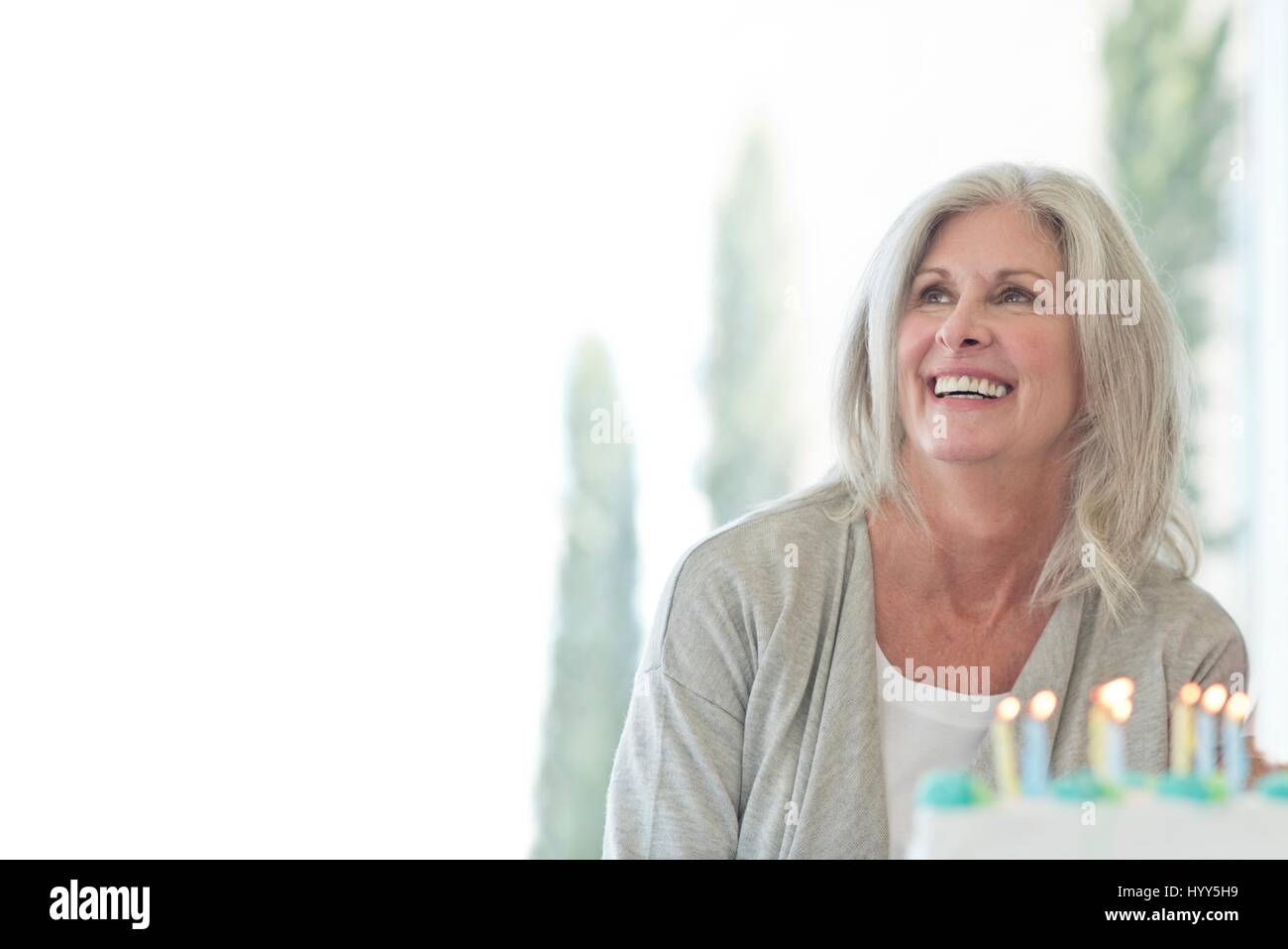 Ältere Frau mit Geburtstagstorte. Stockfoto