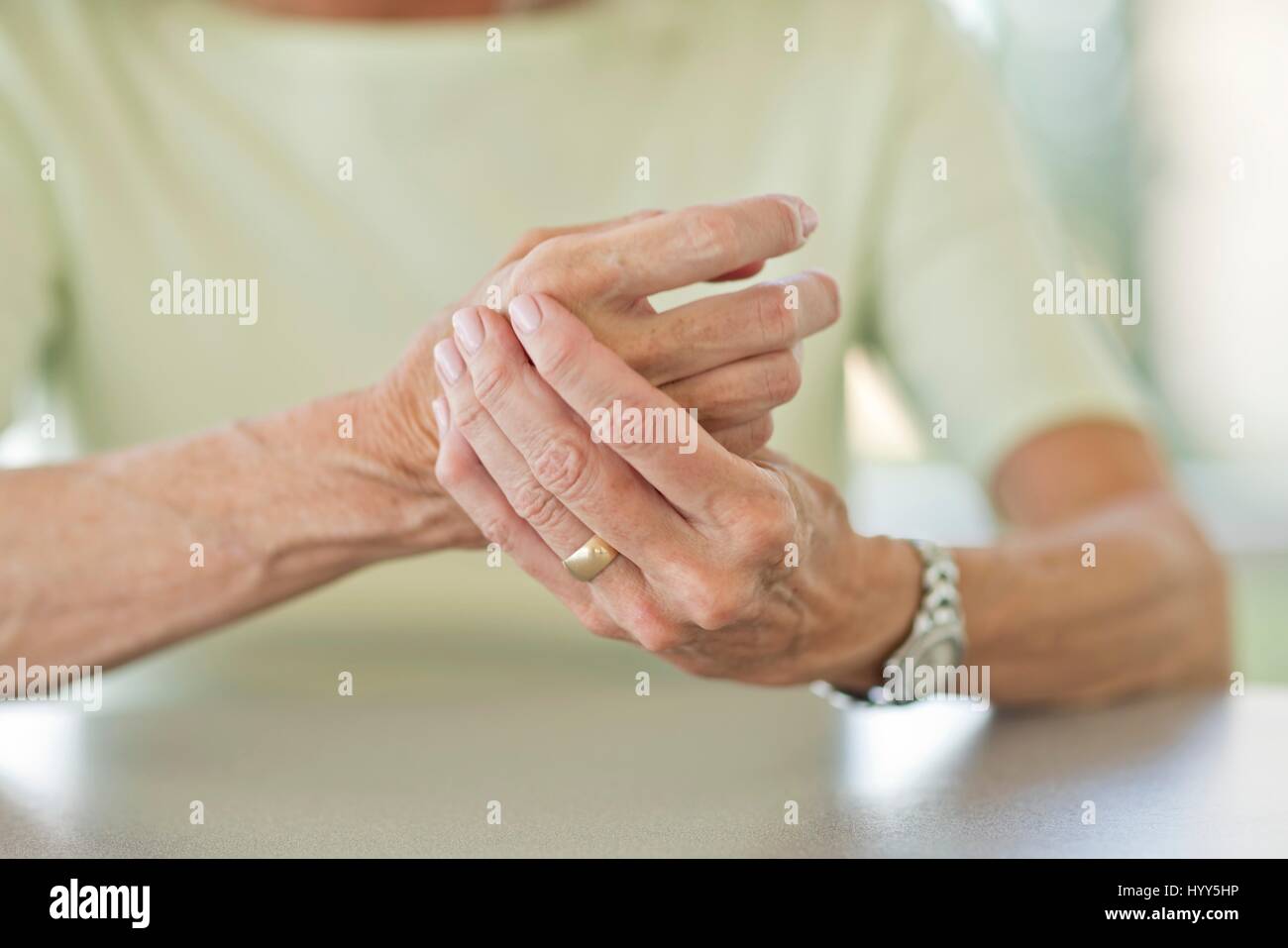 Ältere Frau reiben schmerzhaft Hand. Stockfoto