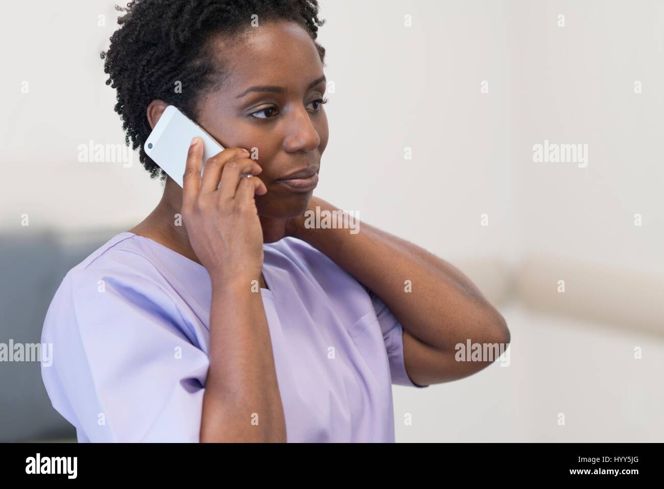 Reife Krankenschwester auf Handy. Stockfoto