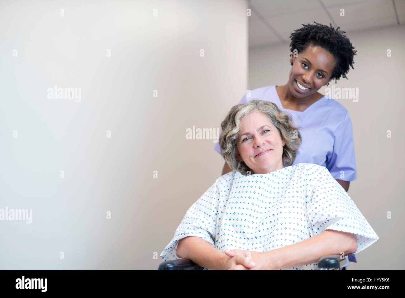 Krankenschwester drängen Patientin im Rollstuhl. Stockfoto