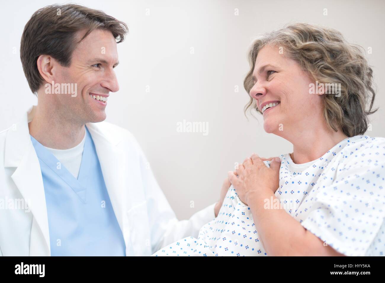 Männlichen Arzt lächelnd an Reife Patientin. Stockfoto
