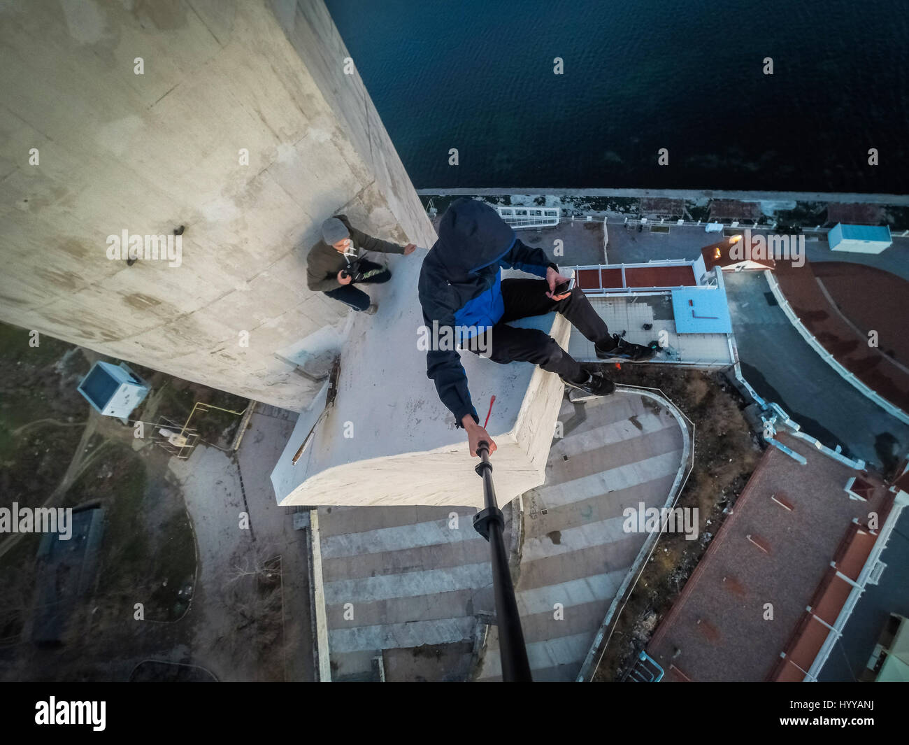 SEWASTOPOL, UKRAINE: Ein Adrenalin-Junkie hat Leib und Leben riskiert nach dem Klettern eines 195-Fuß hohe Denkmals für russische WW2 Kriegshelden nur um ein neues Video über die Stadt zu bekommen. Schwindelerregenden Bild- und Filmmaterial zeigen die furchtlosen Kletterer Bundle eine Leiter auf der Innenseite des Turms vor zu Fuß auf eine Oberfläche, die bei 45 Grad, ohne Sicherheitsausrüstung abgewinkelt ist. Der Rooftopper Spaziergänge auf die geneigte Fläche, bis er den Rand erreicht, wo er sitzt und seine Beine während beiläufig SMS auf seinem Handy baumelt. Das Herzschlagfinale Video wurde auf der Bajonett-Segel-Obelisk in Sevastopo gefilmt. Stockfoto