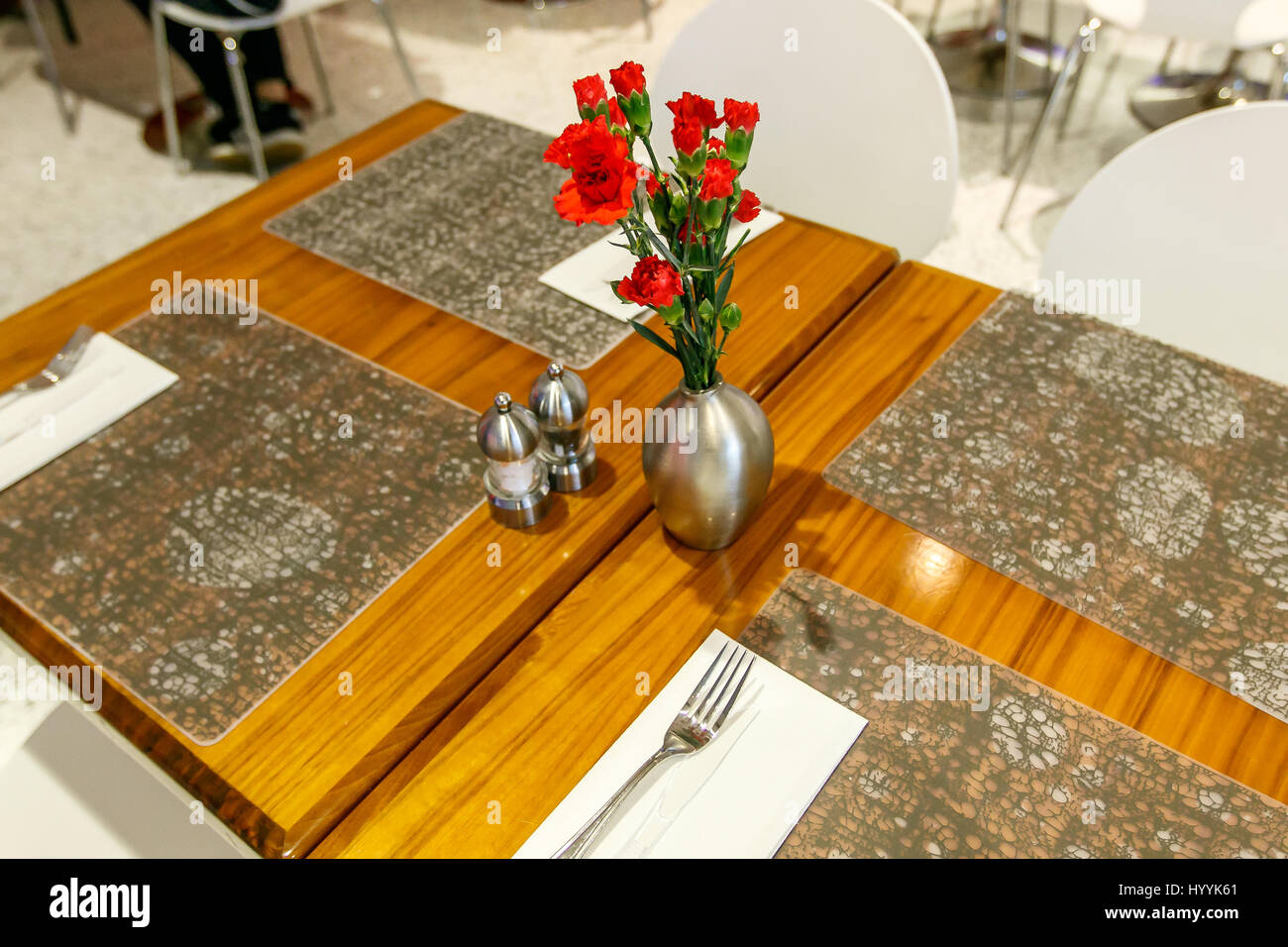 Tabellen sind festgelegt und dekoriert mit Nelken in einem Restaurant in einem Flughafen. Stockfoto