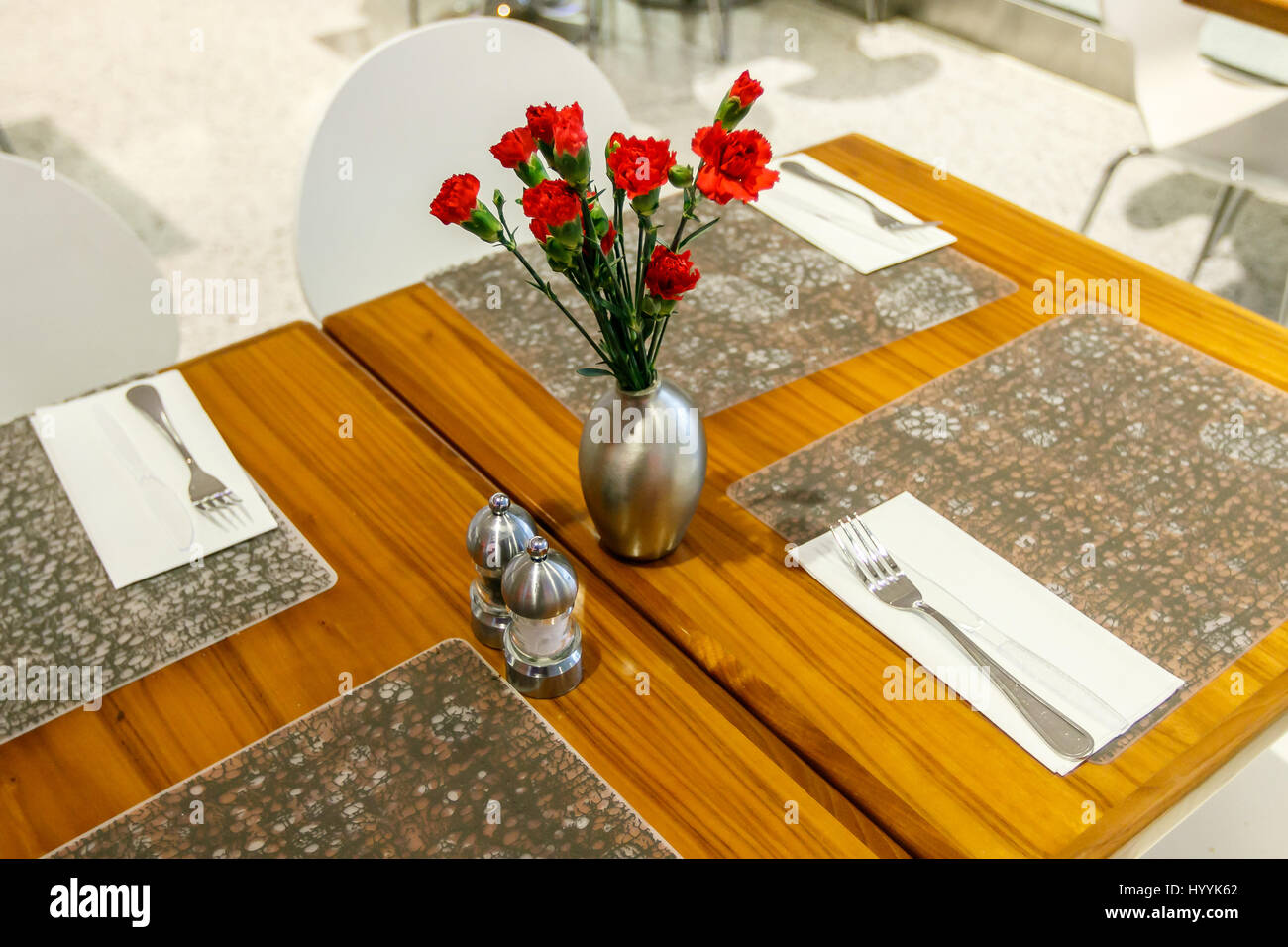 Tabellen sind festgelegt und dekoriert mit Nelken in einem Restaurant in einem Flughafen. Stockfoto