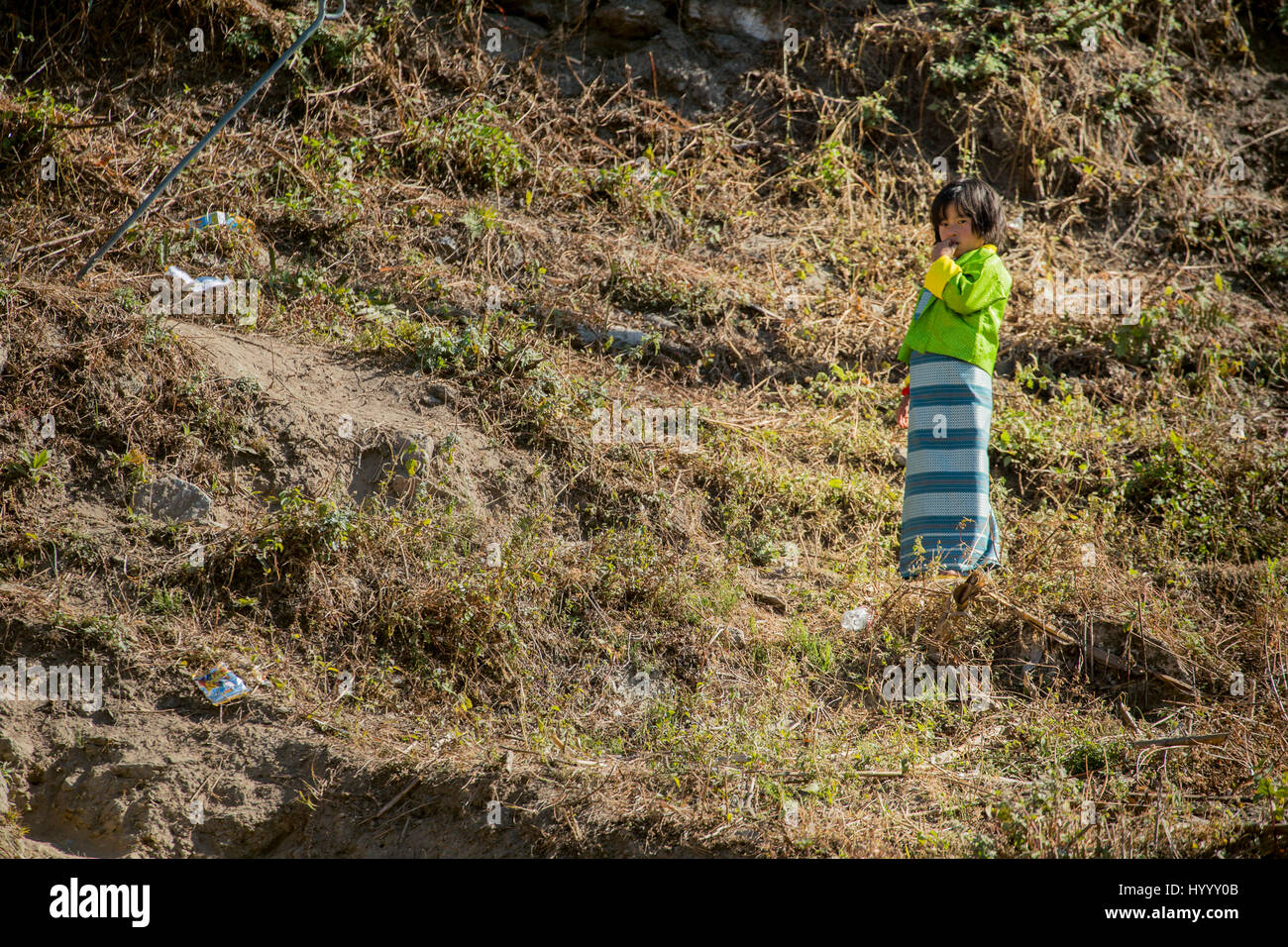Bhutan Mädchen Kira stehend in der Mitte von Plastikmüll Stockfoto