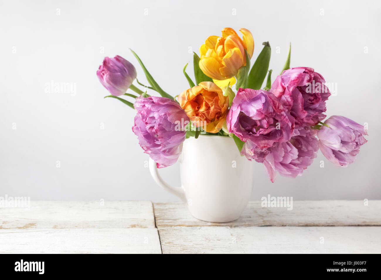 Frischen Strauß Tulpen im Topf auf rustikalen Holz. Vintage Stil Stockfoto