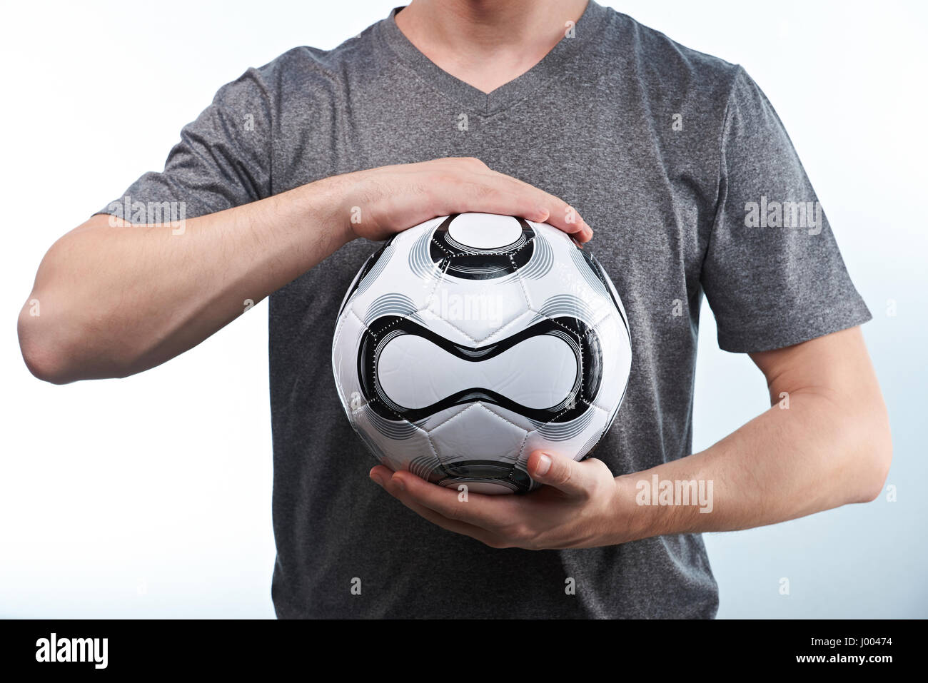 Mann halten moderne Fußball-Ball mit beiden Händen isoliert auf weißem Hintergrund Nahaufnahme Stockfoto