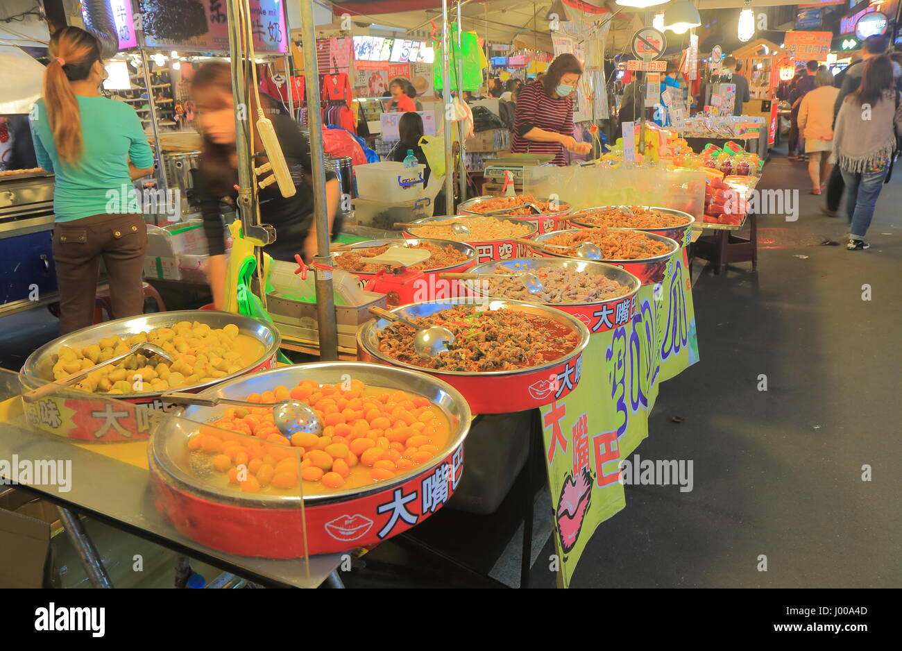 Leute kochen traditionelles taiwanesische Essen im Rao Nachtmarkt in Taipei, Taiwan. Rao Nachtmarkt gehört zu den ältesten Nachtmarkt in Taipei. Stockfoto