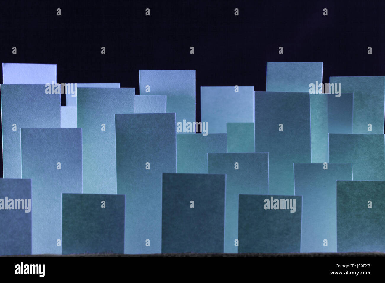 Makro-Zusammensetzung der klebrigen blauen Papierfähnchen auf schwarzem Hintergrund Stockfoto