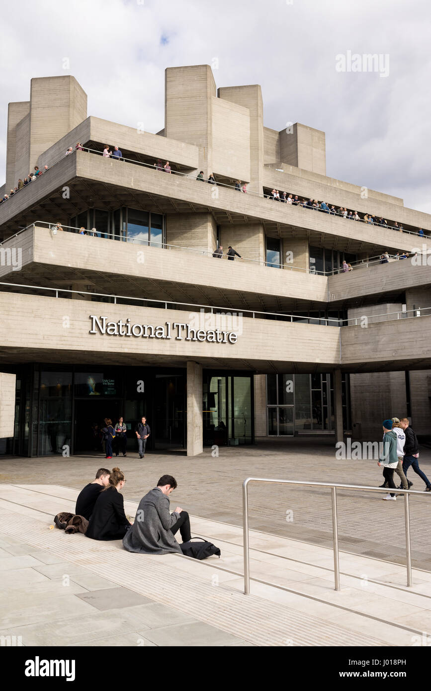 Menschen außerhalb des Royal National Theatre an der Londoner South Bank sitzen. Das Royal National Theatre ist eines der Vereinigten Königreich der drei wichtigsten Promi Stockfoto