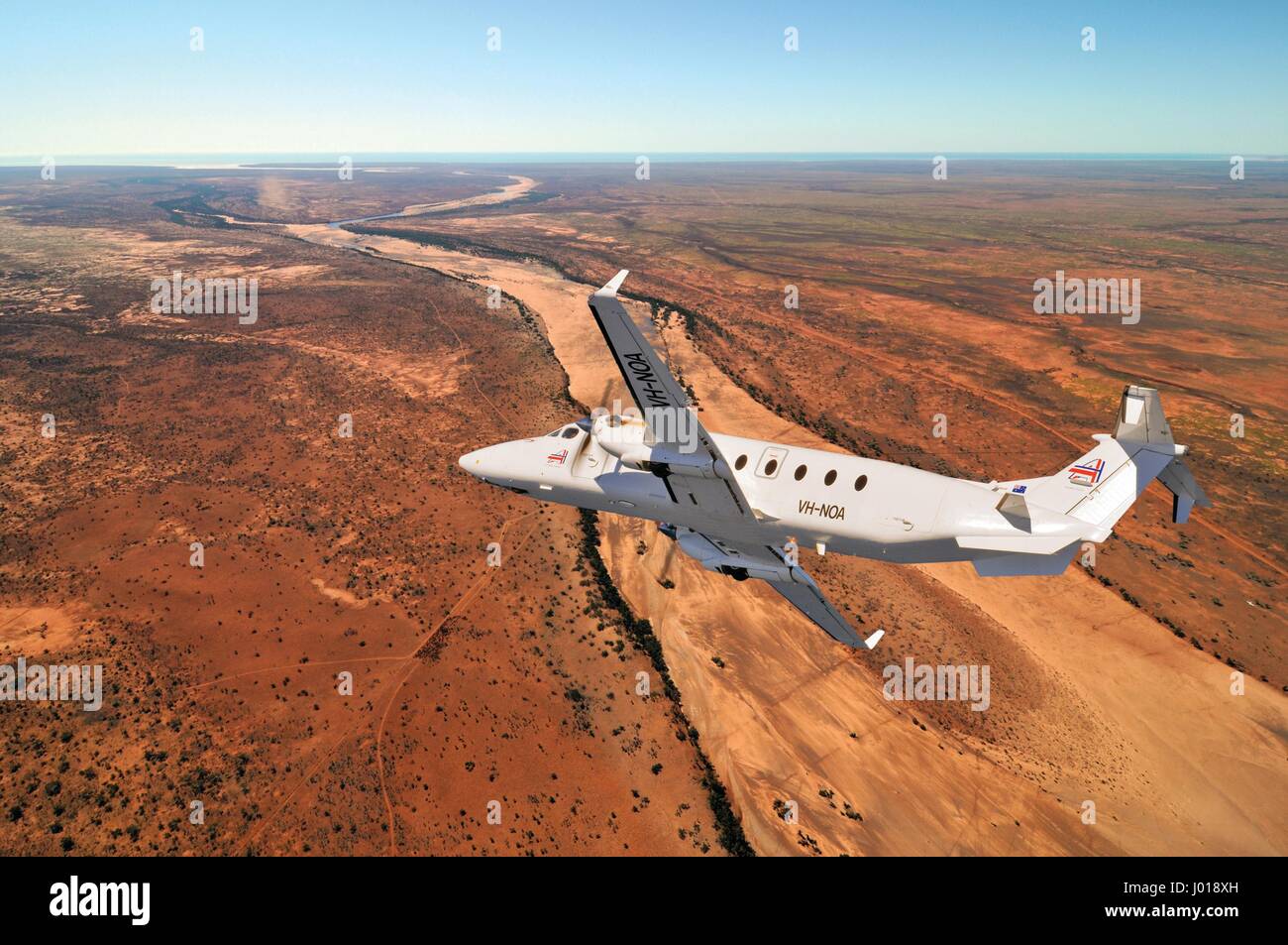 Eine Luftaufnahme des eine Beechcraft B1900D Kurzstrecke / charter Flugzeug Banking über das australische Outback. Stockfoto