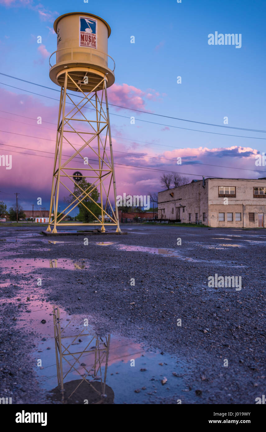 Wasserturm vor einem farbenfrohen Sonnenuntergang Himmel in Oklahoma Music Hall of Fame in Muskogee, Oklahoma-Depot-Distrikt. (USA) Stockfoto