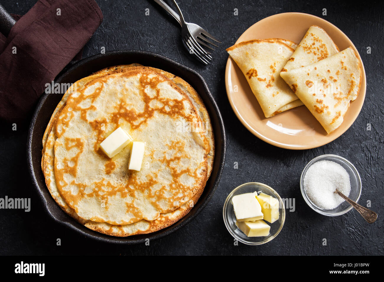 Hausgemachte Crepes mit Butter in Gusseisen Pfanne bei rustikalen ...