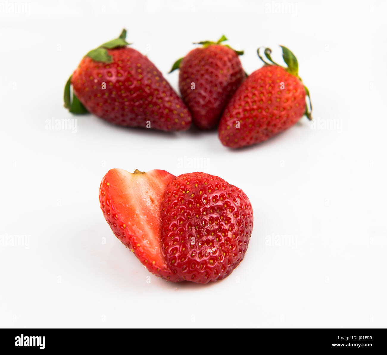 Frische leckere rote Erdbeeren isoliert auf weiss. Erdbeeren sind mit grünen Stängel und Blätter Stockfoto