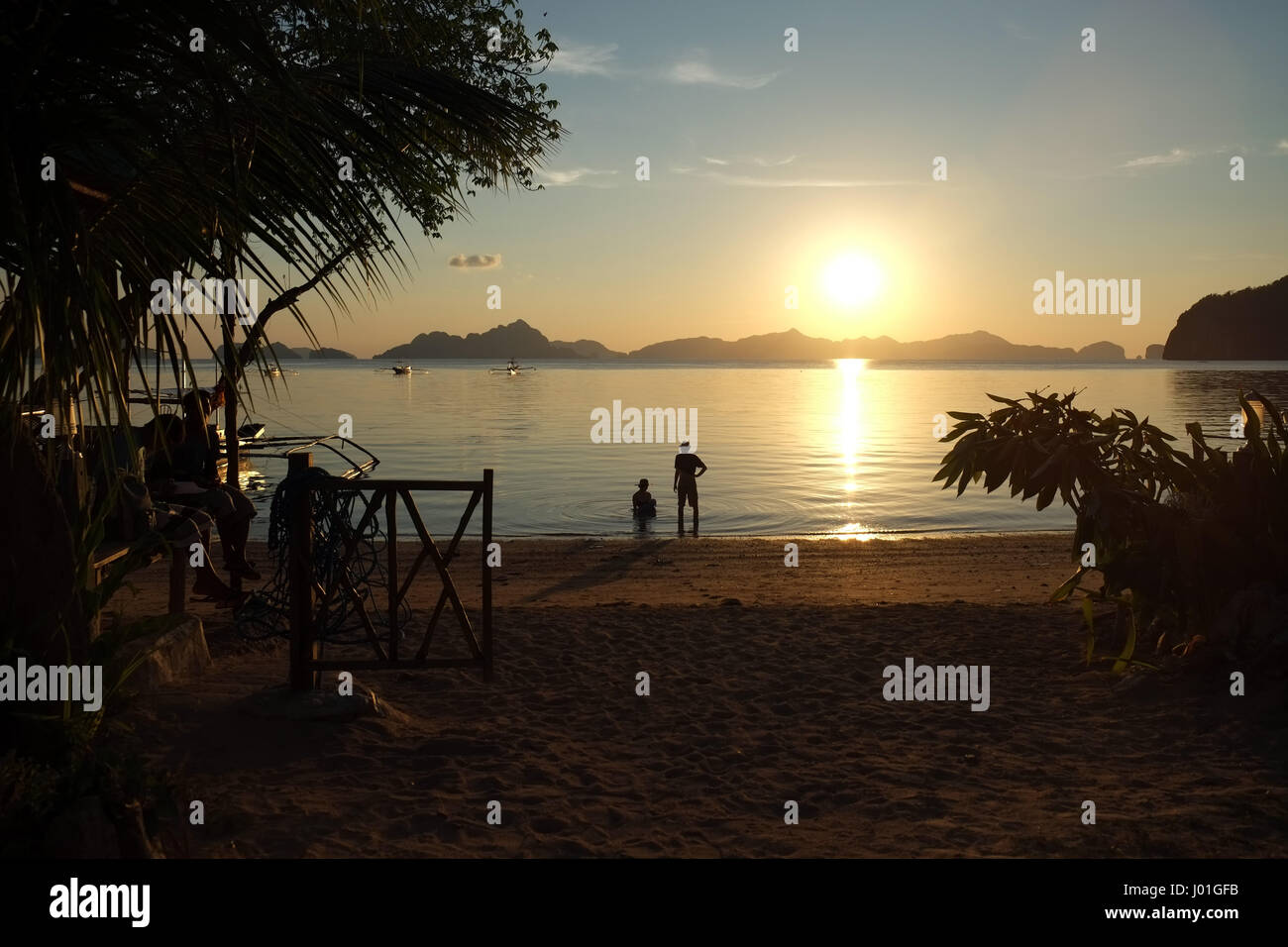 Zwei Personen am Strand bei Sonnenuntergang in Palawan in einem Kabinen-resort Stockfoto