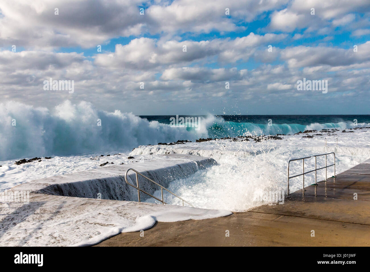 Grobe Wellen überfluten einen künstlichen Pool Stockfoto
