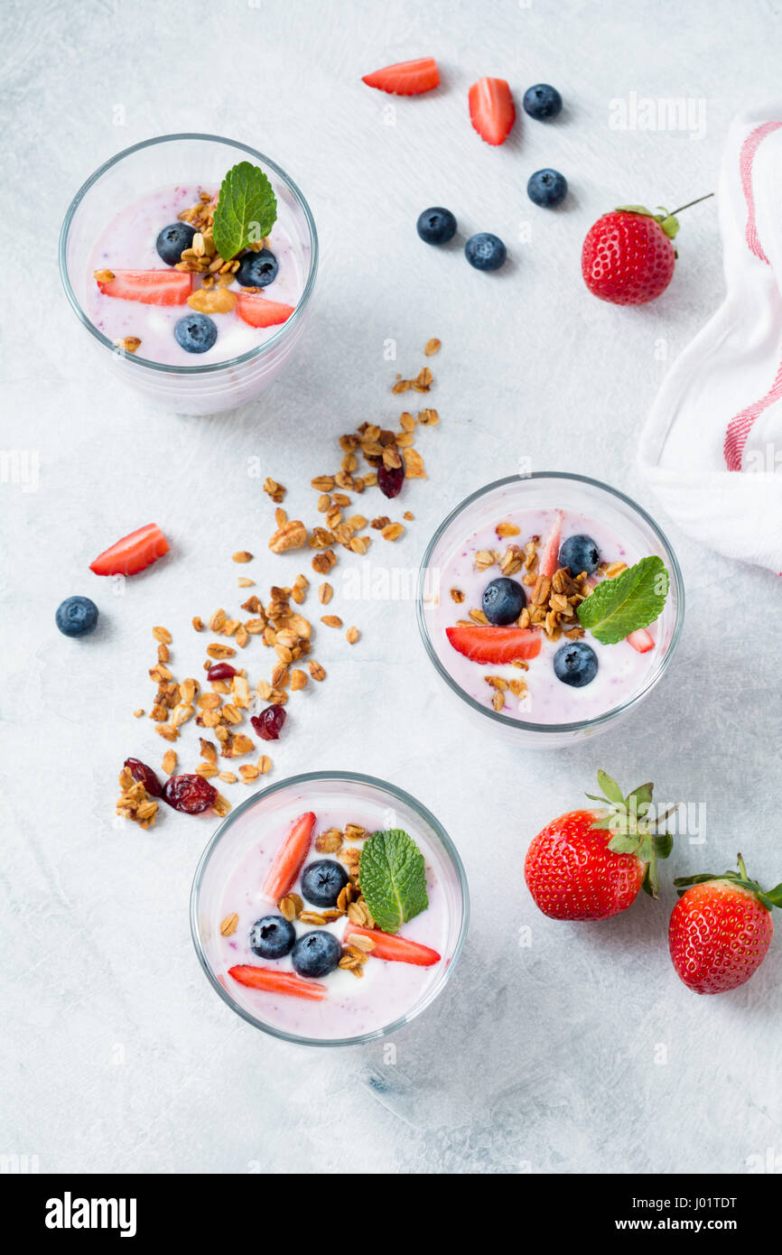 Joghurt-Frucht-Smoothie mit frischen Erdbeeren, Heidelbeeren und Müsli Stockfoto