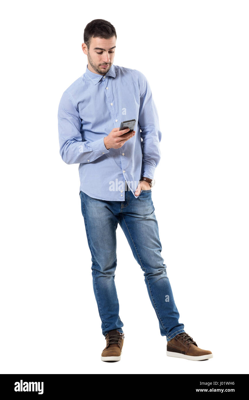 Entspannte junge smart casual Business-Mann Nachricht auf dem Handy zu schreiben. Ganzkörper-Länge-Porträt isoliert auf weißem Hintergrund. Stockfoto