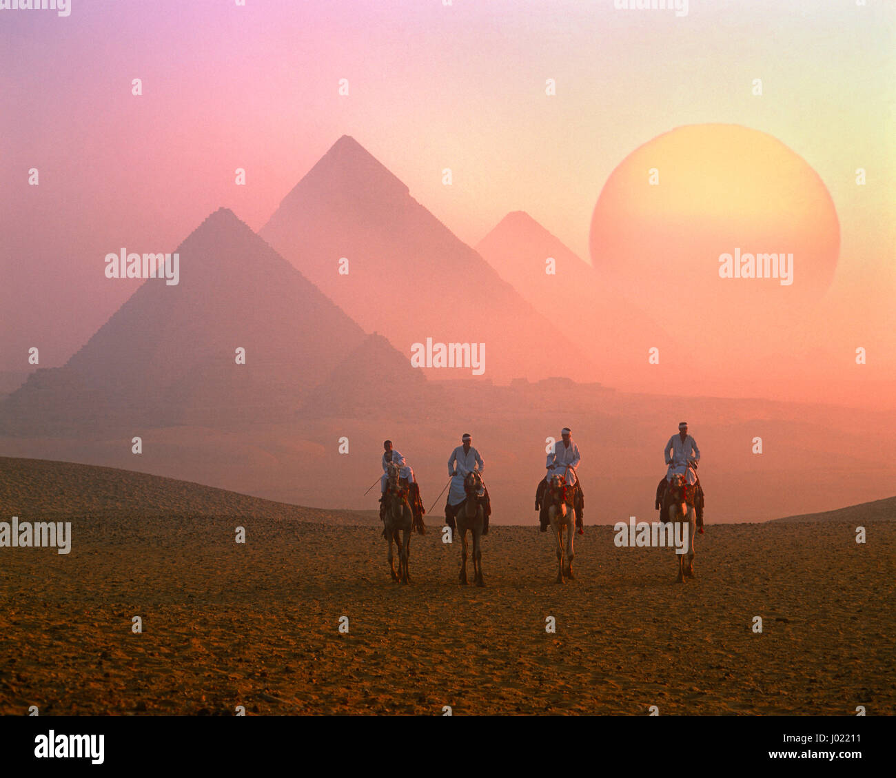 Vier Fahrer Kamel, die Pyramiden und die aufgehende Sonne, Gizeh, Kairo, Ägypten Stockfoto
