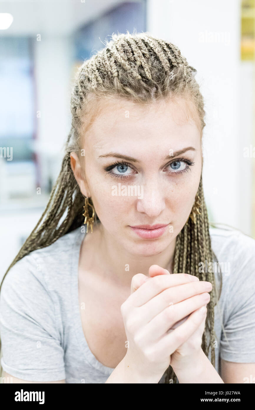 Closeup ehrliche Porträt einer echten Frau in ein echtes Büro, blaue Augen und Rasta Haar Stockfoto