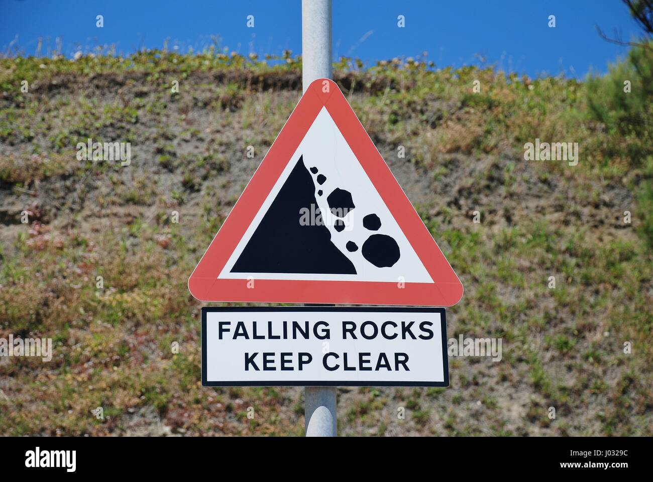 Eine öffentliche Zeichen Warnung vor der Gefahr von Steinschlag unter den Klippen direkt am Meer in Folkestone in Kent, England. Stockfoto