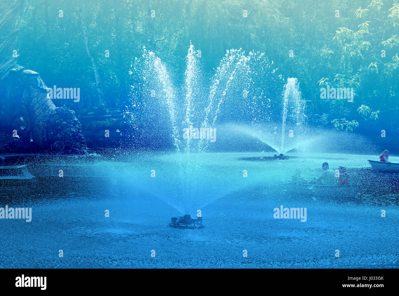 Schöne Teiche mit Springbrunnen und Boote mit Menschen Fotos abstrakt blau Stockfoto