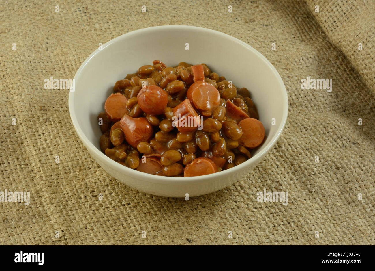 In Scheiben geschnitten Türkei Hot Dog Würstchen und gebackenen Bohnen in Schüssel weiß Stockfoto