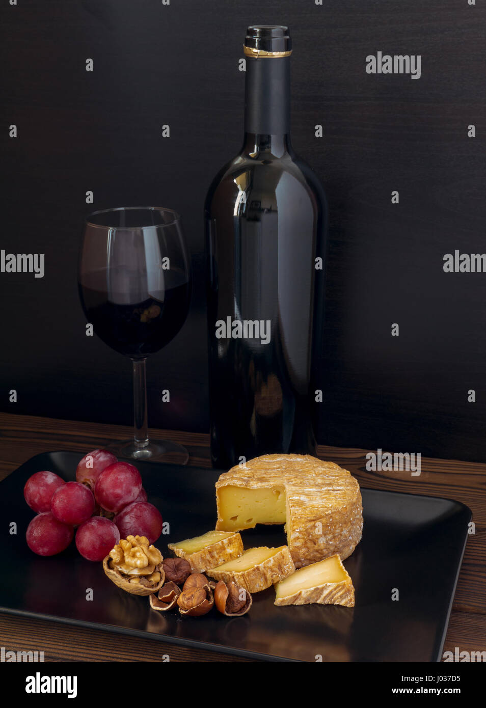 Waschen-Rinde Käse, Haselnüsse, Walnuss, Rote Traube und Wein im Glas und Flasche Stockfoto